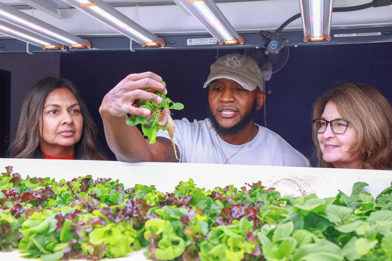 Desmond Hayes holding greens grown at iA Labs